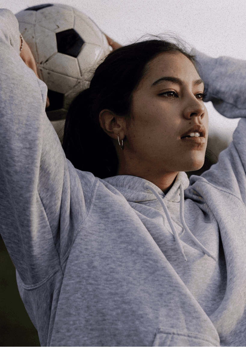 woman in a hoodie throwing a football